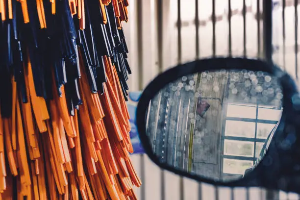 Photo of View of a side mirror of the car and orange brushes on automatic car wash