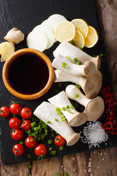 Raw King Brown Mushroom with ingredients for cooking close-up. Vertical top view