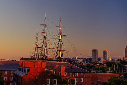 masts of a historic ship on the background of the setting sun