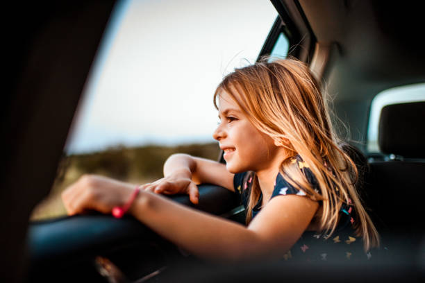 Girl looking out car window stock photo