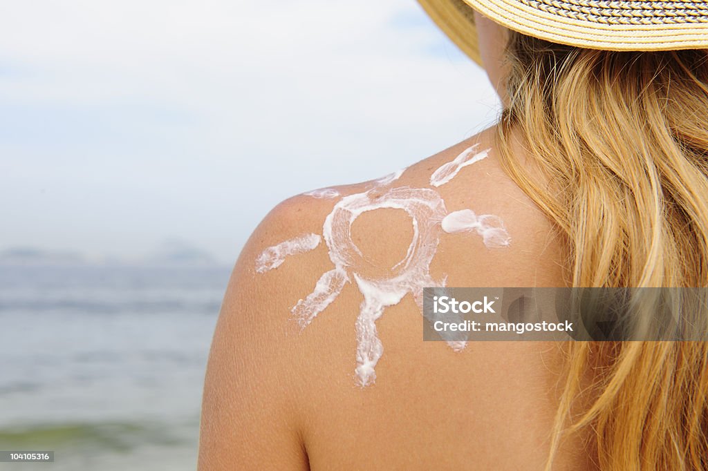 woman with suntan lotion on her skin at the beach  Suntan Lotion Stock Photo