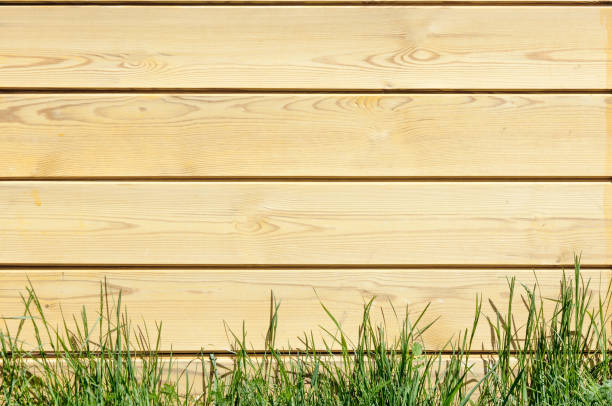 istock Texture, background, pattern. Good background. The boards are connected as a shield. A wooden wall with green grass. Wood texture, Natural wood background. 1041061610