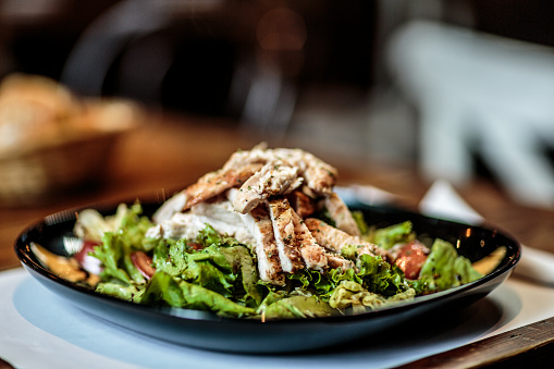 Close up view of a plate with delicious meat salad on the table.