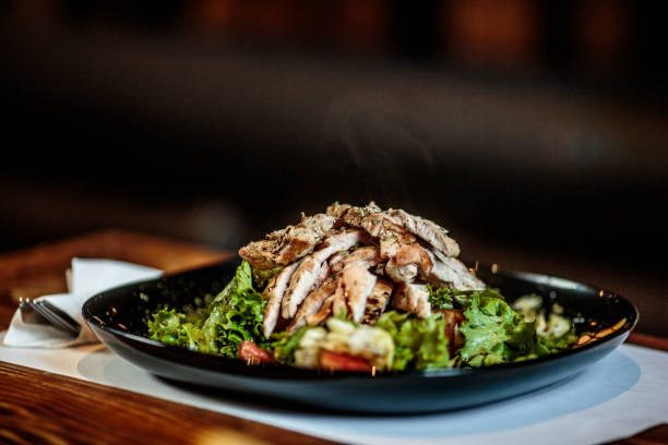 тарелка с едой на столе - grilled chicken salad salad dressing food стоковые фото и изображения
