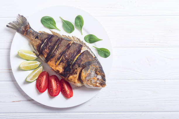 istock Fried fish dorado with lime , tomatoes and spinach 1041075534