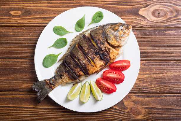 istock Fried fish dorado with lime , tomatoes and spinach 1041075658