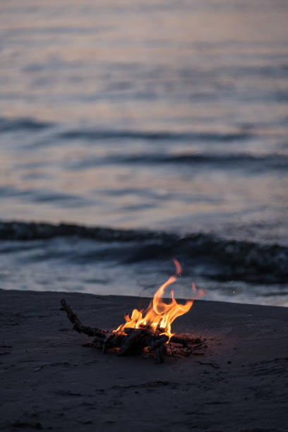 istock small fire burning on the sea shore at night 1041082358