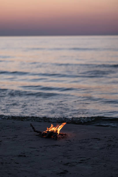 istock small fire burning on the sea shore at night 1041082382