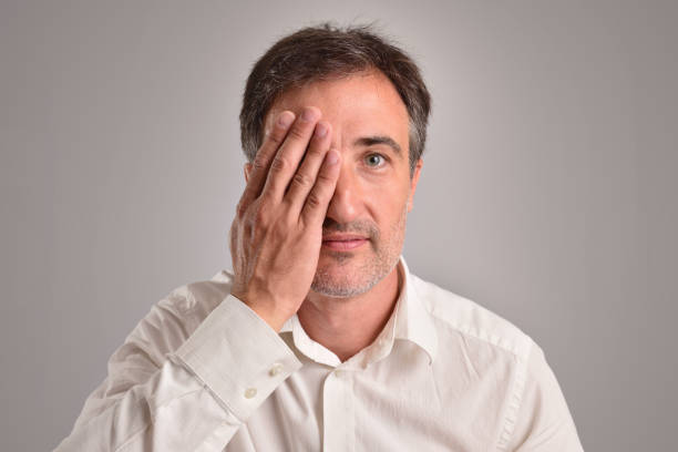 istock Middle-aged man covering an eye for optical revision 1041087428