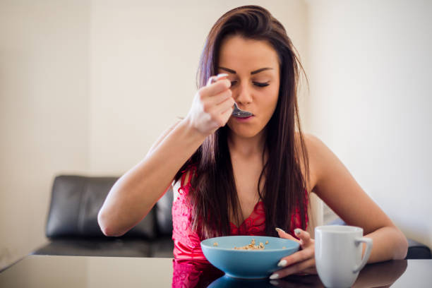 istock Beautiful young woman using smartphone while having a healthy breakfast at home 1041087676