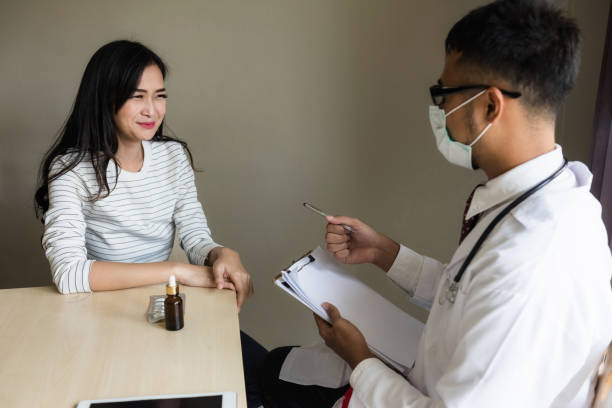 medico asiatico diagnostica donna paziente in ospedale - patiient foto e immagini stock