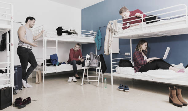 istock Young men and women friendly interacting while staying in modern comfy hostel 1041092450