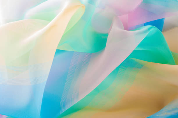 istock Texture, background, pattern. Silk fabric is transparent, yellow-pink green in blue. Abstract soft chiffon texture background. 1041093776