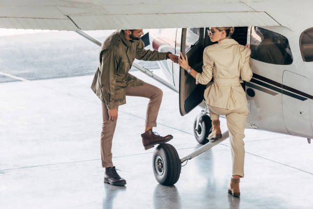 istock smiling young man opening door for girlfriend while she boarding in airplane 1041103830