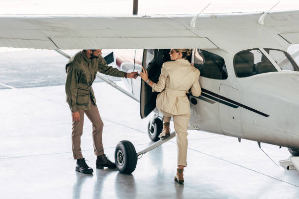 istock stylish young man opening door for girlfriend while she boarding in plane 1041104070