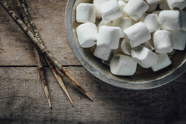Bowl of marshmallows and skewers stock photo
