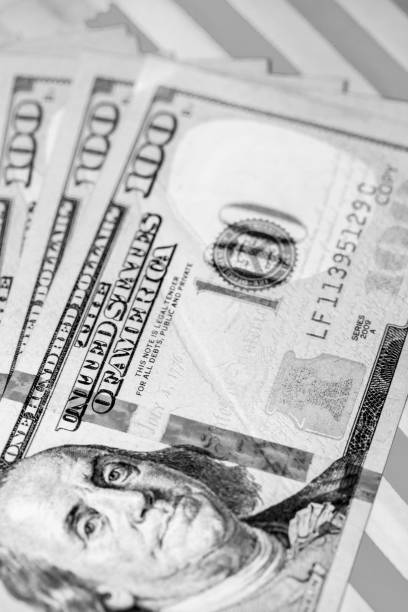 istock Hundred Dollar Bills fanned on Red & White Background (B&W Green Filtered) 1041111332