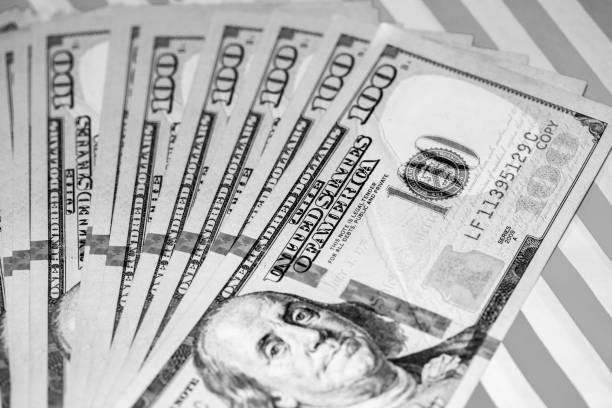 istock Hundred Dollar Bills fanned on Red & White Background (B&W Green Filtered) 1041111394