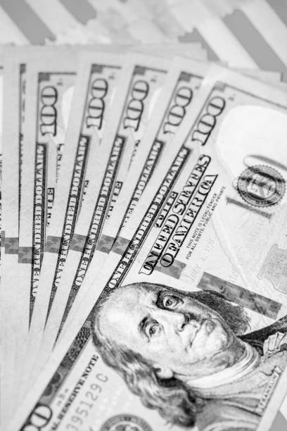 istock Hundred Dollar Bills fanned on Red & White Background (B&W Green Filtered) 1041113618