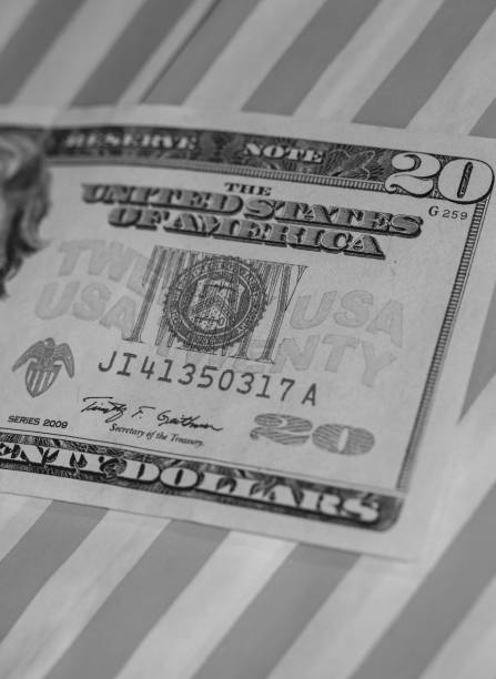 istock A Twenty Dollar Bill on Red & White Striped background (B&W Green Filtered) 1041113862