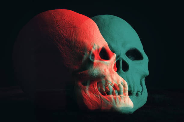A double exposure image of two creepy skulls lit with red and cyan.