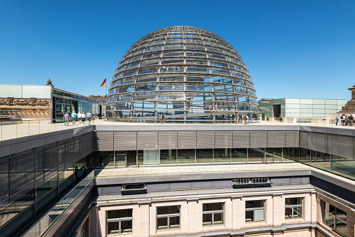 Berlin, Germany - May27, 2017: People walk near the Reichstag Roof Dome. It is a glass dome constructed on the top of the Reichstag (Bundestag) building, designed by architect Norman Foster.