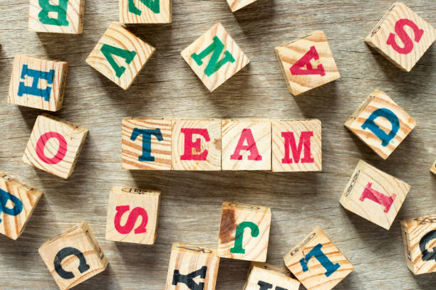 istock Letter block in word team with another on wood background 1041123722