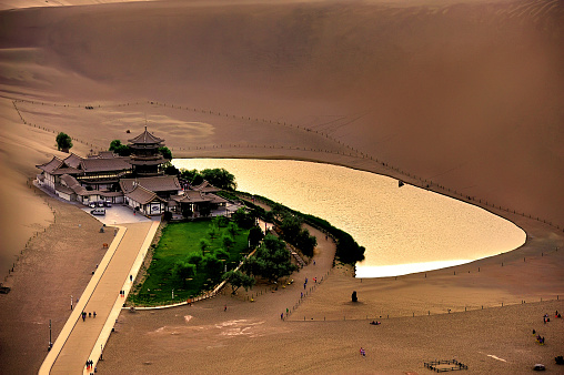 Tourists were visiting crescent lake, the oasis in the desert of Soughing Dunes (Mingshashan) in Dunhuang, Gansu, China