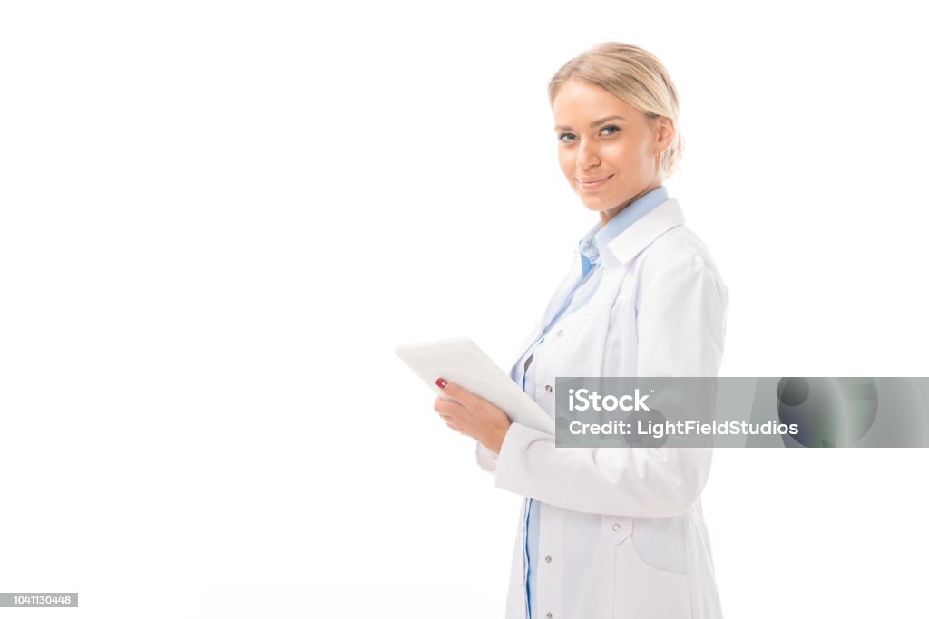 happy young female doctor working with tablet and looking at camera isolated on white Doctor Stock Photo