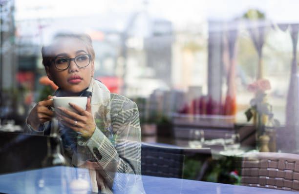 istock Young blondie asian female drinking coffee and looking through window. 1041144836