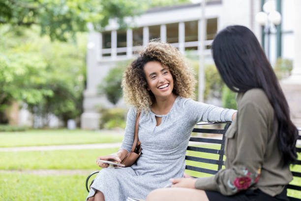 istock Female university student relaxes outside with friend 1041145500