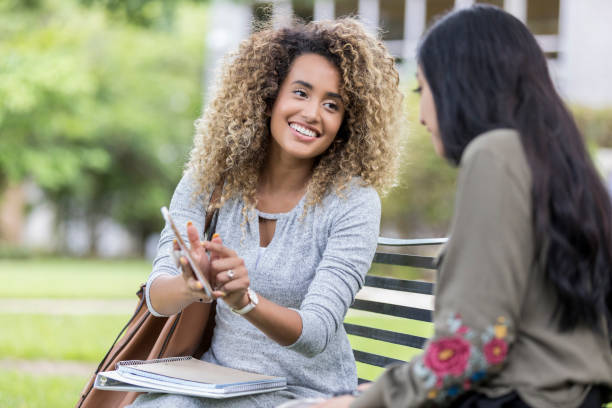 istock Female university student shares mobile app with friend 1041145530