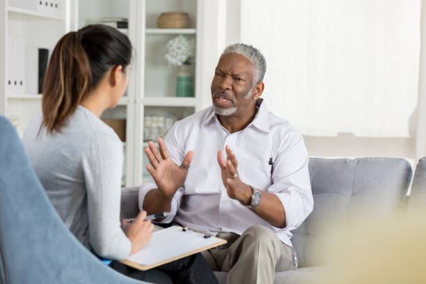 istock Upset senior man talks with female counselor 1041147598