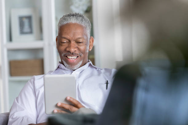 istock Cheerful man uses digital tablet in his home 1041147622