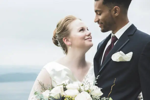 Photo of Closeup of bride smiling at her groom outdoors