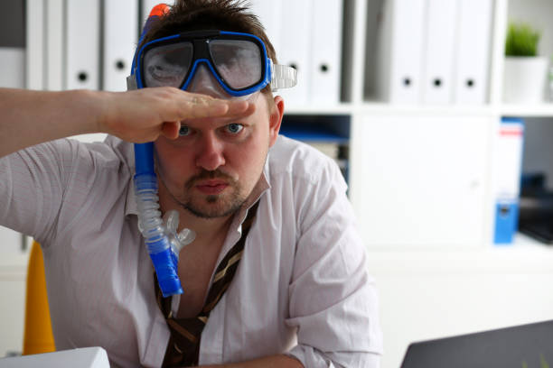 istock Man wearing suit and tie in goggles with snorkel 1041148642