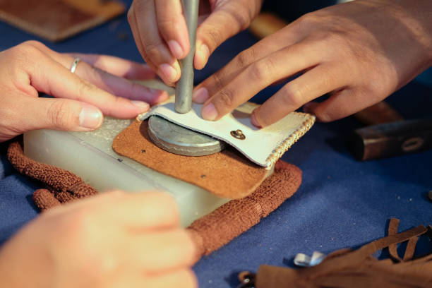 istock craftsman pinching button on leather bag. handmade DIY handicraft 1041150022