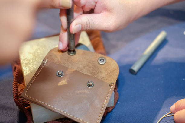 istock craftsman pinching button on leather bag. handmade DIY handicraft 1041150028