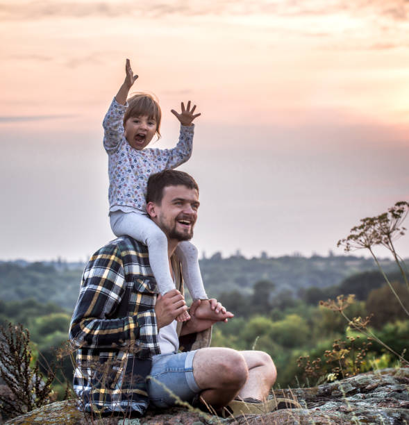 istock dad with little cute daughter at sunset 1041159858