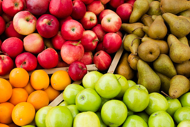 Fresh apples and fresh cranberries at a local farmer's market with the stall showing out of focus in the background