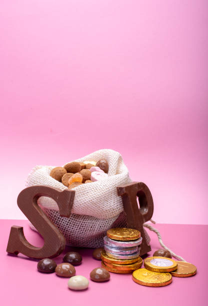 st.nicholas day in december, children holiday in netherlands, belgium, germany and curacao, chocolate spicy ginger cookies, letters and coins on pink background copy space - piet imagens e fotografias de stock