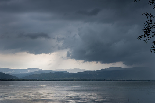 Dark stormy clouds over the river. Landscape.