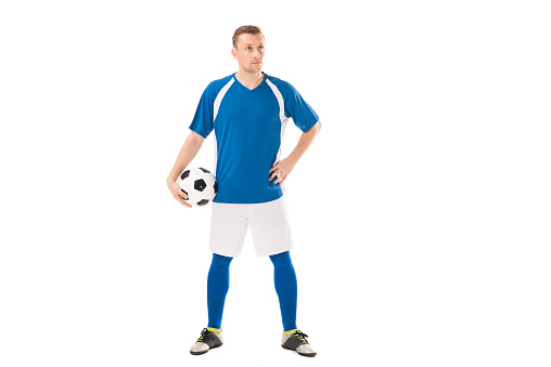 Full length of aged 30-39 years old who is tall person with short hair caucasian male sportsperson exercising in front of white background wearing t-shirt who is showing cool attitude and holding soccer ball and using sports ball