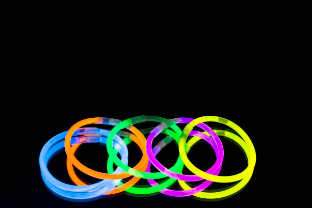 istock Colorful fluorescent light neon glow stick bracelet strap wristband on mirror reflection black background 1041176364