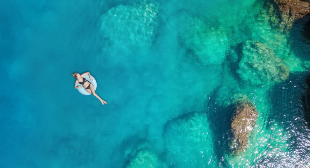 vista aérea da garota no mar. água azul-turquesa do ar como pano de fundo do ar. paisagem natural na época de verão. fruits de zangão - boia equipamento de desporto aquático - fotografias e filmes do acervo