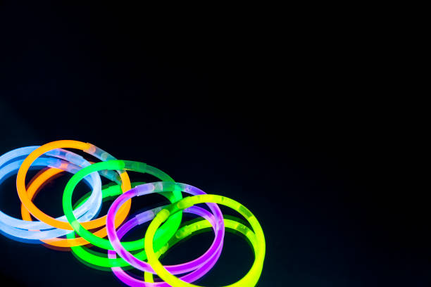 istock Colorful fluorescent light neon glow stick bracelet strap wristband on mirror reflection black background 1041176920