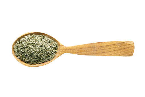 sage dried for adding to food. spice in wooden spoon isolated on white. seasoning of delicious meal.