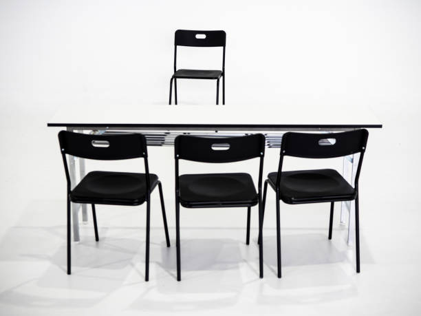 istock Black chairs with white table on white background. Interview place concept 1041191662