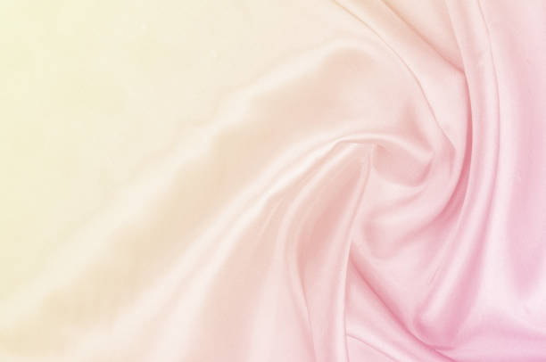 istock Background pattern, texture. Silk fabric yellow pink pastel tones. Silk background in pink and yellow colors. 1041195706