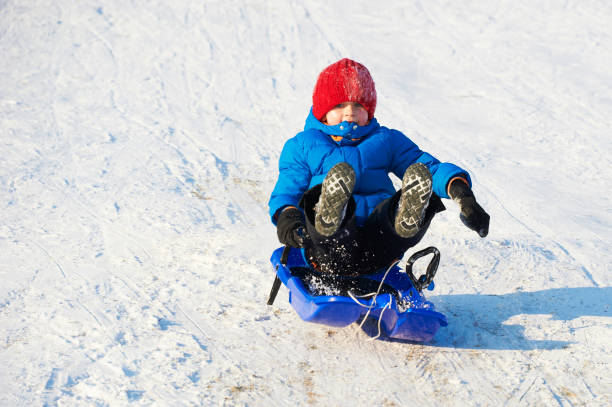 istock Child boy jumping on bobsled. 1041200946
